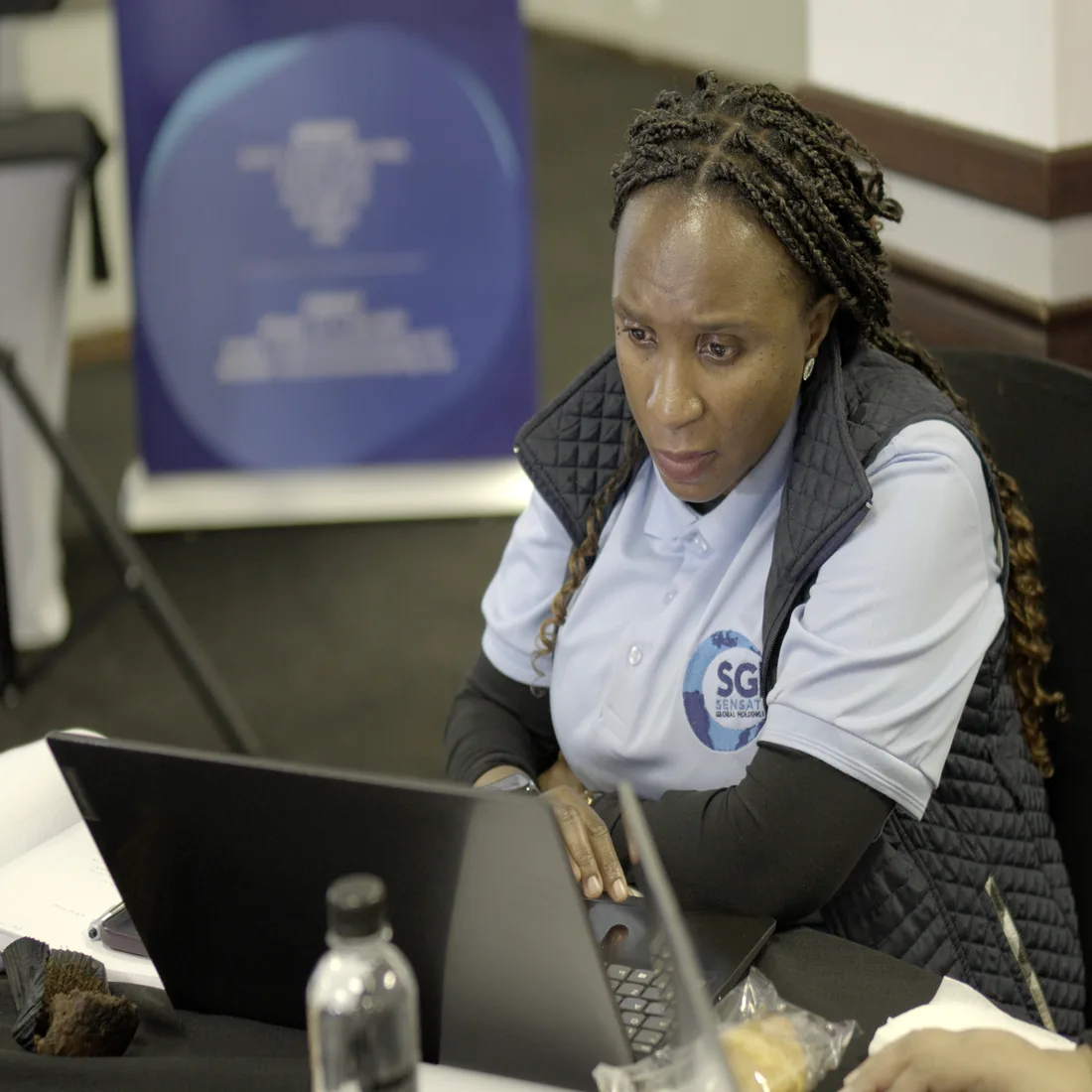 A Sensation Global Holdings staff member concentrating on her work at a laptop.