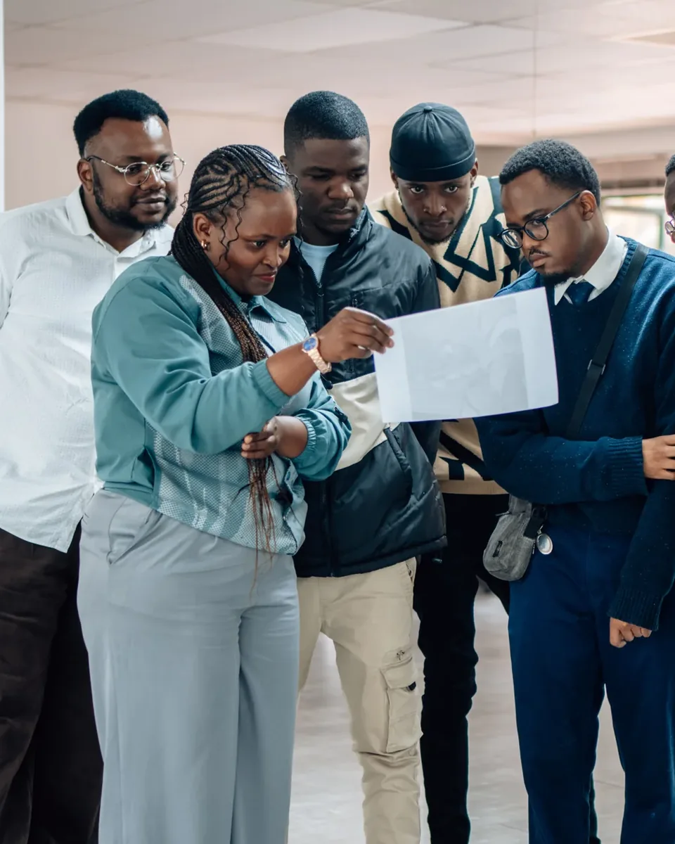 Young people at a youth skills workshop, reading a document together.
